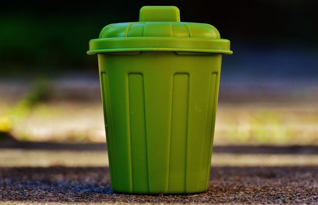 zielony kosz na śmieci z przykrywką