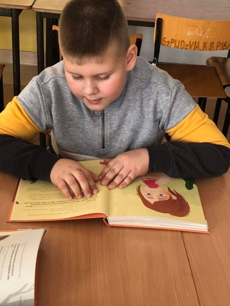 Na zdjęciach dzieci ze Szkoły Podstawowej w Wierzbnie czytające książkę 