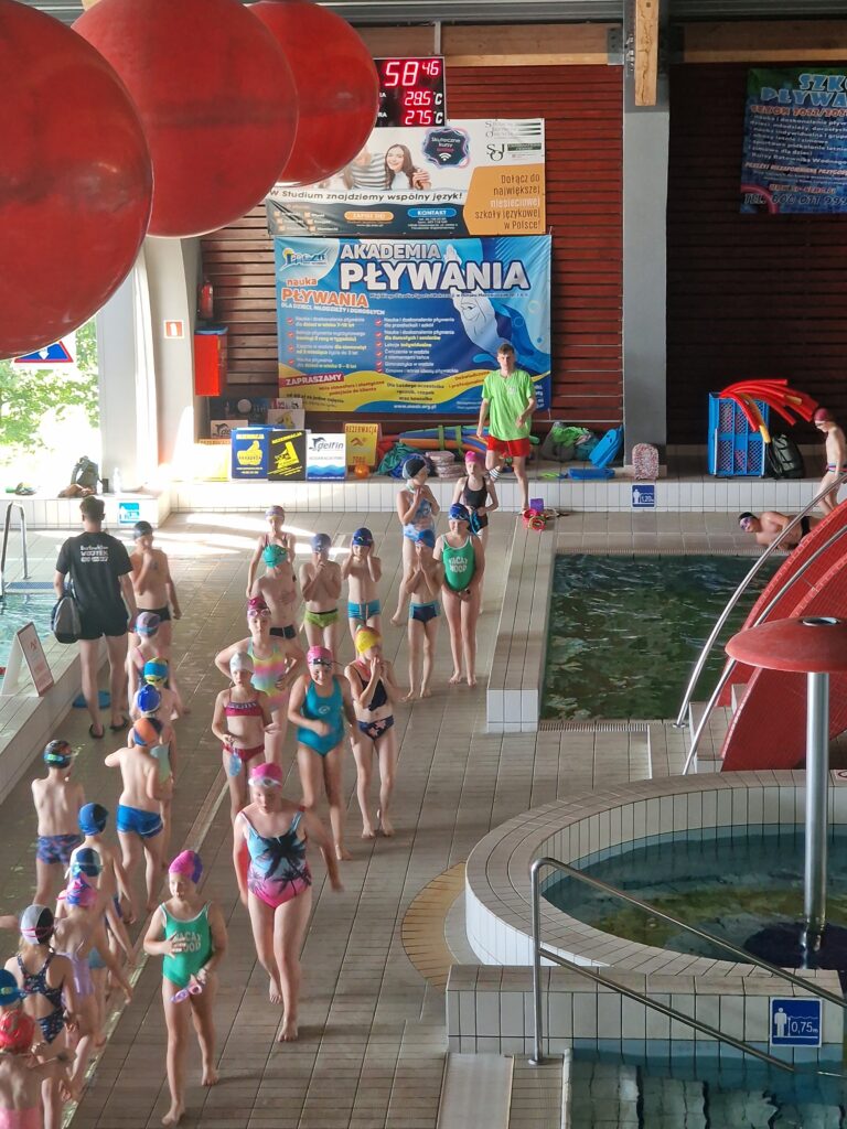 Na zdjęci8ach dzieci w grupach pływające na basenie, logo Ministerstwa Sportu