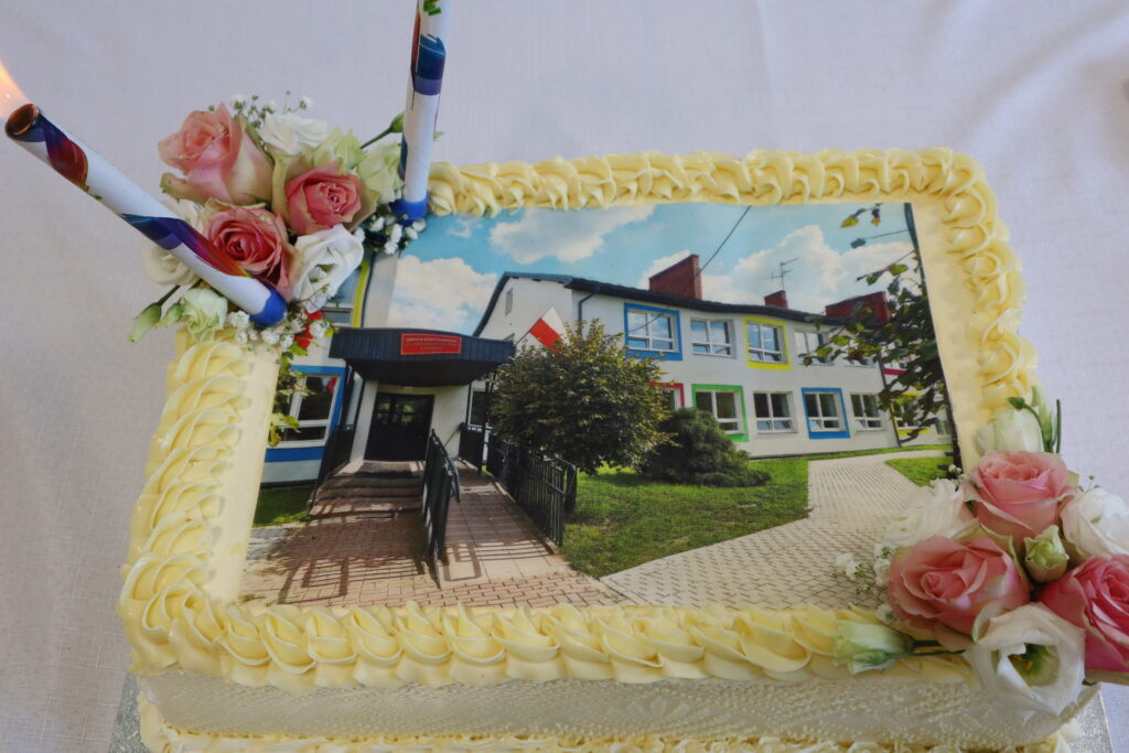Na zdjęciu jest ciasto, ozdobione obrazkiem domu. Ciasto wygląda apetycznie i jest oczywiste, że jest przygotowane na świętowanie w specjalnej okazji.