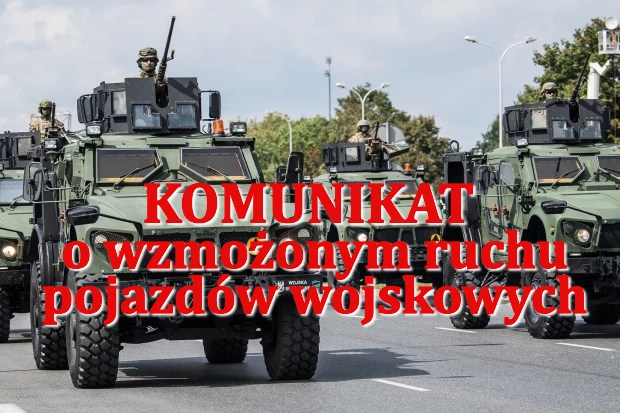 Konwój zielonych pojazdów wojskowych na drodze. Na tle drzew i latarni znajduje się napis o wzmożonym ruchu.