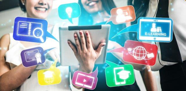 Trzy osoby trzymają tablet, wokół kolorowe ikony edukacji i mediów. Tło białe, ikony wzmocnione niebieskim. Dynamiczne i nowoczesne.